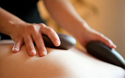 A woman receiving a hot stone massage
